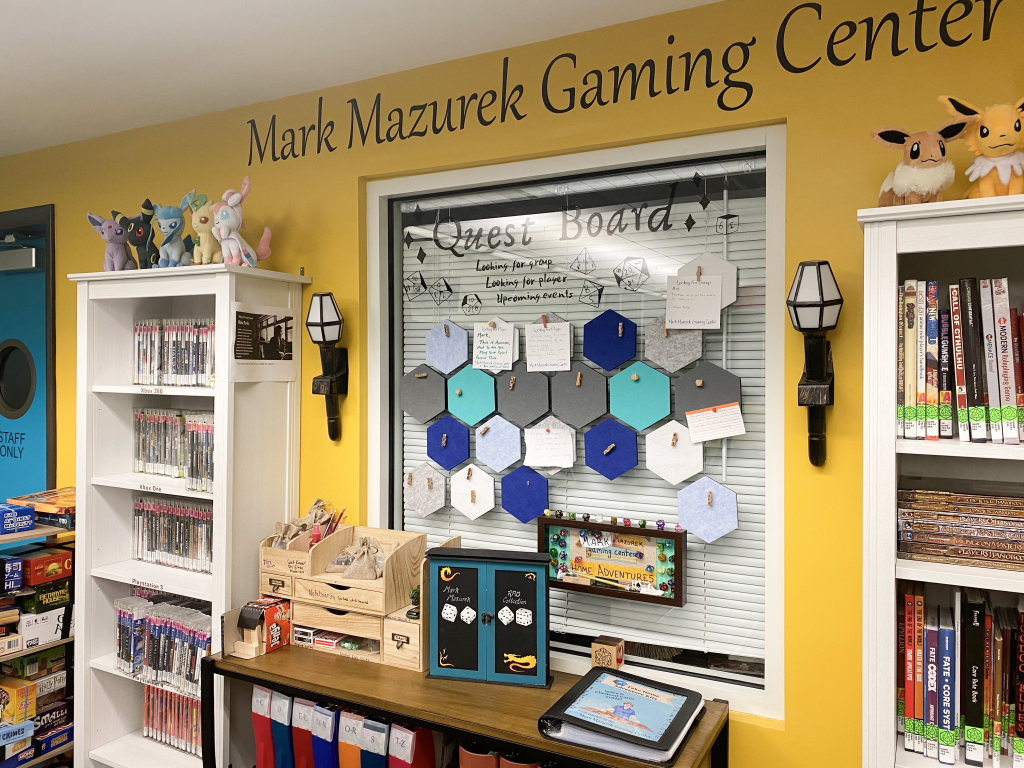 Mark Mazurek Gaming Center written on wall with shelves of games and video games