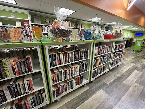 Bright green shelves of books with wrapped baskets on top.