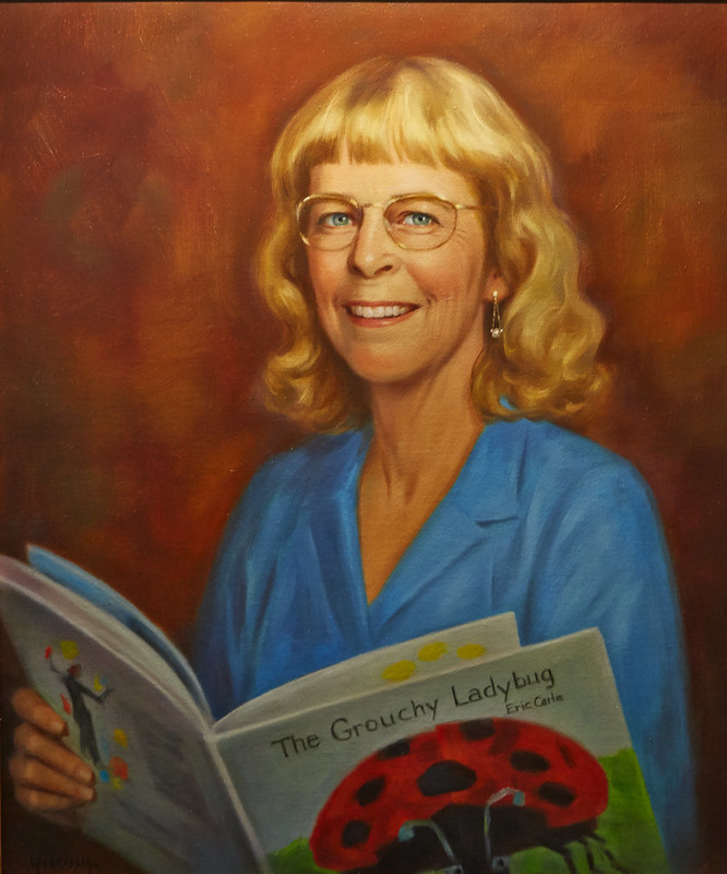A painting of a woman holding a book.